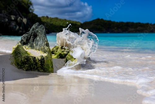 Fotografi Wave Splash Over Mossy Rock on Tropical Beach in St John US Virgin Islands