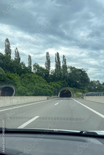 Highway leading into two tunnels on a cloudy day