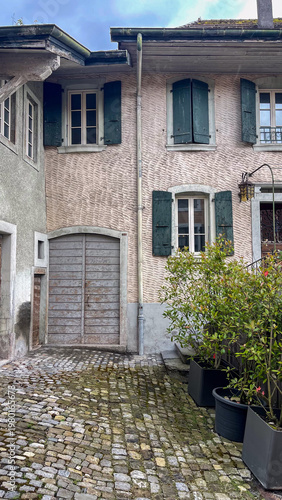 Cobblestone Alleyway with Old European Buildings and Green Shutters