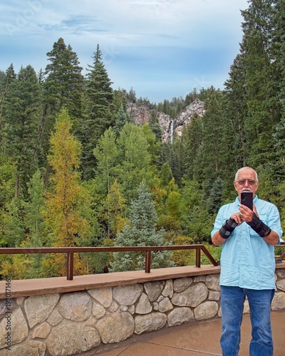 Senior man with wrist braces taking selfie  at Treasure Falls Colorado