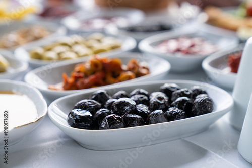Close-up view of black olives and meze platters, traditional Turkish breakfast