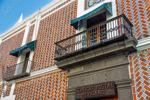 Puebla, Mexico - January 19, 2025: Ornate wrought iron balconies with green awnings and Talavera tile facade at Former Federal Palace now housing Mexican Post Office in Puebla, Mexico