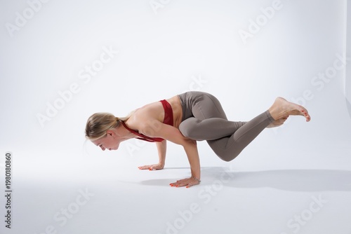 Photos Athletic woman performing an advanced yoga inversion pose in a minimalist studio setting