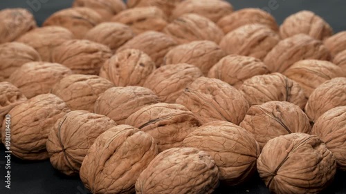 High-angle oblique view of whole organic walnuts in shells with selective focus and pleasing bokeh. Natural food concept for healthy diet projects.