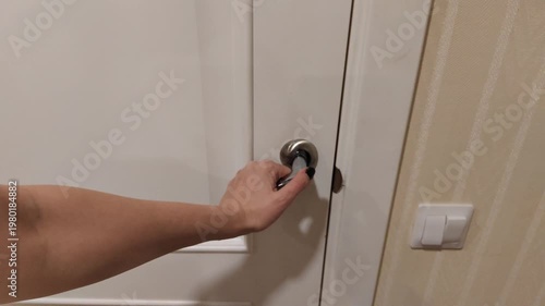 Close-up of a hand turning a door handle, opening and closing a door. Everyday household action, access and security concept, home or office entrance, movement between rooms and daily routine.