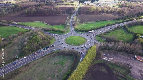 Heavy traffic congestion and vehicle movement on the Sheriffhall Roundabout near Edinburgh. High-angle view of the major road junction connecting the A720 City Bypass and A7