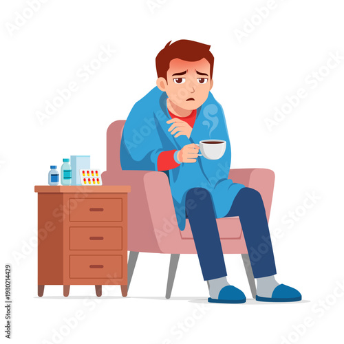 Sick young man sitting in a chair wrapped in a blanket holding a steaming mug feeling unwell with fever