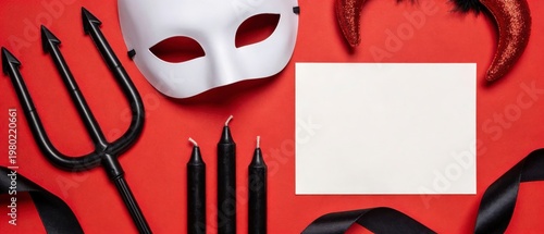 Close crop of a white masquerade mask, black trident, black candles, glitter horns, ribbon, and blank card on a red background, arranged as a bold Halloween or costume party frame with copy space
