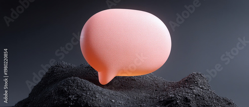 A soft pink 3D speech bubble resting on a dark textured ground, symbolizing digital communication and quiet contemplation.