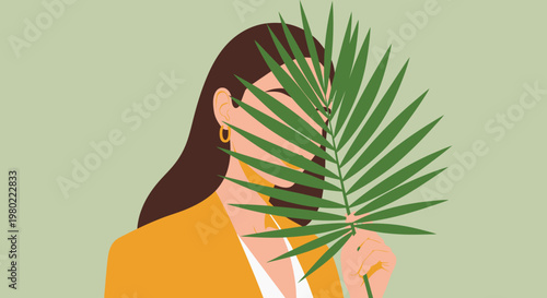 A woman in a yellow blazer partially obscured by large vibrant green tropical leaves creating a stylish portrait
