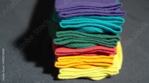 Close-Up Panning Shot of a Stack of Multicolored Socks on a Dark Background | Row of Neatly Folded Bright Hosiery | Daily Routine and Household Organization Concept