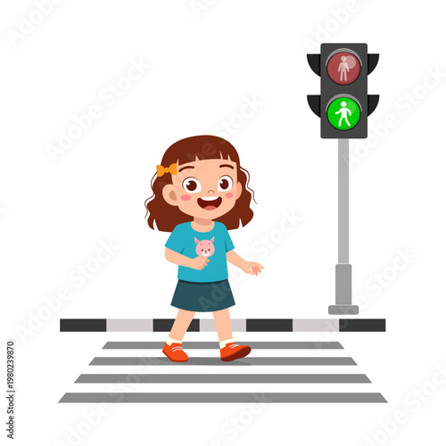 Happy little girl smiling and safely crossing the street at a pedestrian crosswalk with a green walk signal