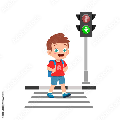Happy little boy with a blue backpack cheerfully crossing the road on a crosswalk with a green traffic light