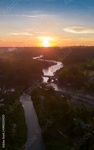 Golden sunset embraces a winding river in a tranquil landscape, showcasing nature's beauty and serenity during twilight hours
