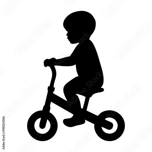 silhouette of a small child riding a balance bike