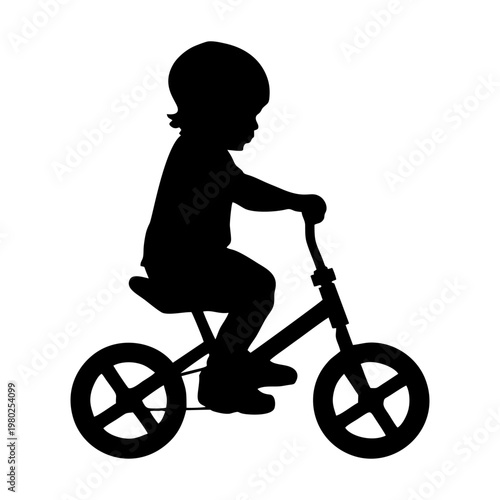 silhouette of a small child riding a balance bike