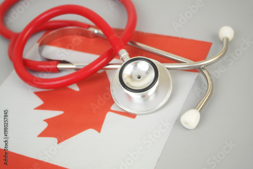 Red stethoscope on flag of Canada. Canadian medicine and health insurance concept.