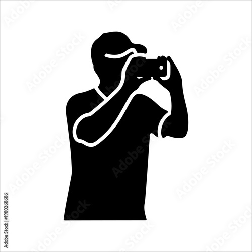 Silhouette of a person holding a camera capturing a moment.