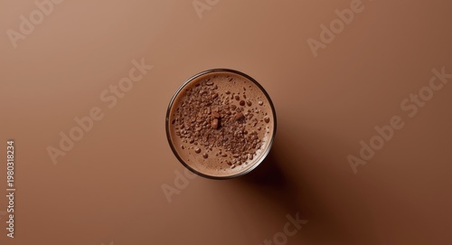 Flat lay photo of a chocolate milkshake glass from top view with isolated plain backdrop