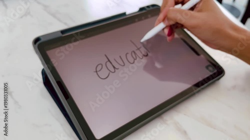 Digital education concept with handwritten word Education on tablet screen using stylus pen. Modern online learning, remote study, and electronic classroom technology for creative students
