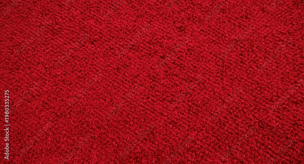 Fototapeta premium Vivid red textured carpet with soft daylight background