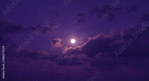 Vivid purple night sky backdrop displaying silhouetted clouds and a bright full moon