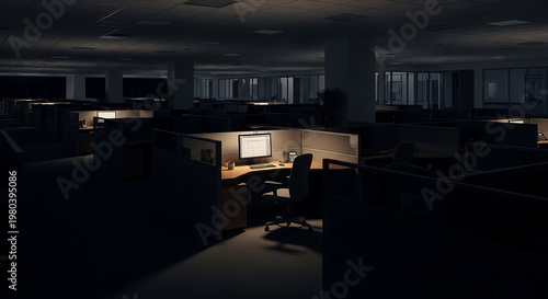 Empty office cubicles in the dark with a single computer monitor illuminated, evoking a sense of isolation and late-night work