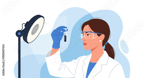 Female scientist in lab coat and goggles examines test tube under bright light