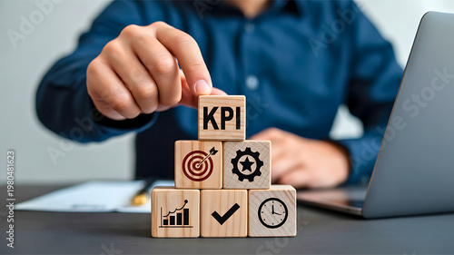 Focused hand places KPI block on business icons, symbolizing strategic performance measurement, goal setting, and analytical management essential for achieving corporate success