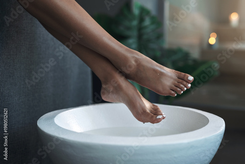Foto Woman, feet and basin with water at spa for detox, cleansing soak and pedicure preparation