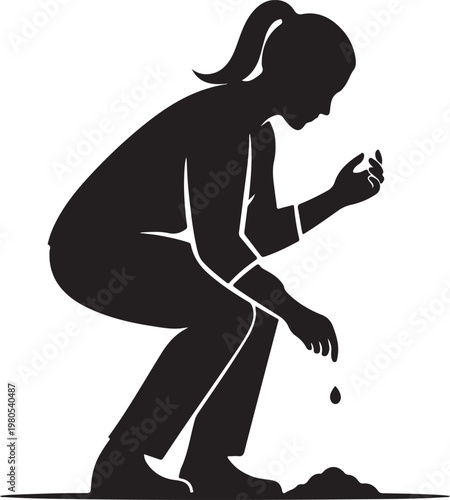 Woman crouching planting seedling