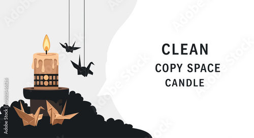 Lit decorative candle with hanging and standing paper origami cranes.