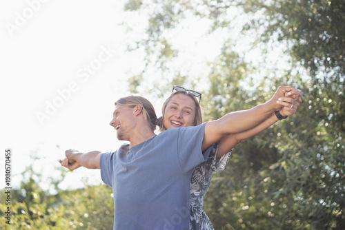 Schilderij op canvas Adventurous couple spreading arms enjoying freedom in sunny  moment