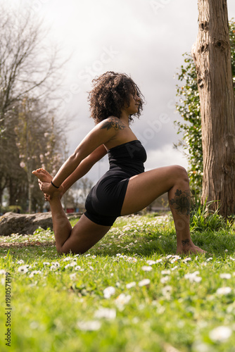 Woman practicing yoga stretching outdoors in park