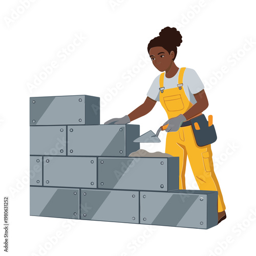 A woman in a yellow jumpsuit is building a wall with concrete blocks.