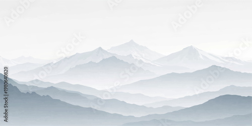 Snowy mountain peaks pierce through a misty winter landscape at sunrise where clouds and fog settle over the alpine valley range