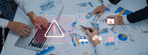 Photos A business team collaborates around a table, analyzing data and charts while highlighting cybersecurity risks, emphasizing proactive management and secure strategies