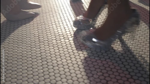  Elegant women's legs wearing high heels on a tiled floor with a moody cinematic atmosphere.
