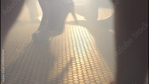  Elegant women's legs wearing high heels on a tiled floor with a moody cinematic atmosphere.
