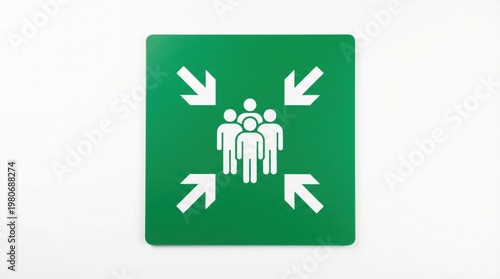 Emergency assembly point sign, green square safety plaque with white people icons and arrows, fire evacuation meeting point symbol on white wall