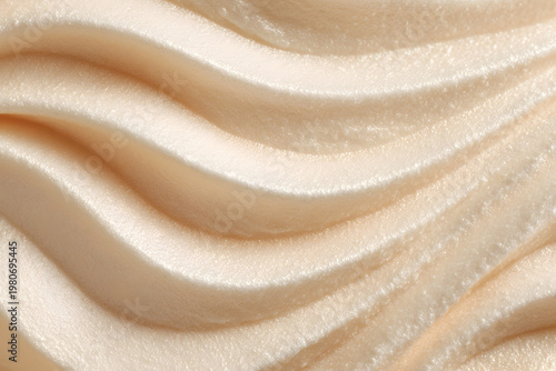 Creamy beige frosting creating a beautiful wave pattern, a textured close up of sweet dessert icing, soft smooth buttercream swirls showing delicious confectionery