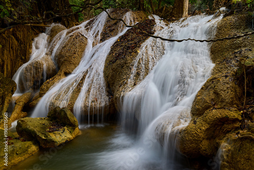 Scenic Waterfall Cascading Over Rocks in Lush Tropical Forest