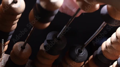 Macro view of vintage wooden abacus beads on rods representing counting calculation education finance and business accounting concept
