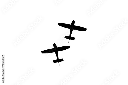 Two vintage airplanes performing an aerial stunt against a clear sky.