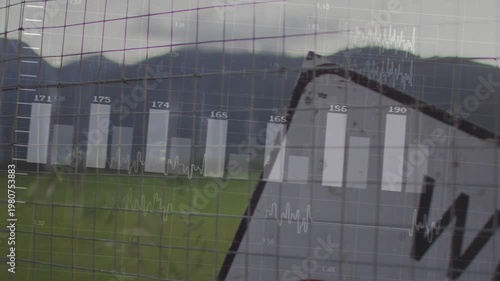 Vertical video: Tilted road sign through wire fence overlay fading in bars rising showing tech data