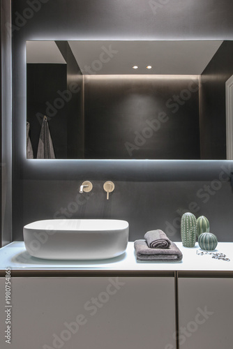 Close-up of a modern vessel sink in a stylish bathroom interior with its mirror