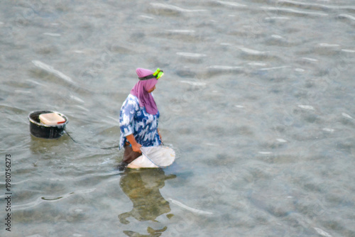 Woman Fishing in Shallow Coastal Water