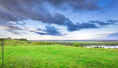 Wallpaper Mural Vast green field stretches under stormy, colorful sky Torontodigital.ca
