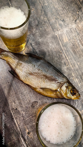 Fishing scene with fish on wood, beer glasses nearby