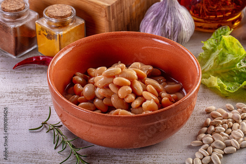 Foto Cooked white beans in a terracotta bowl with fresh vegetables and spices